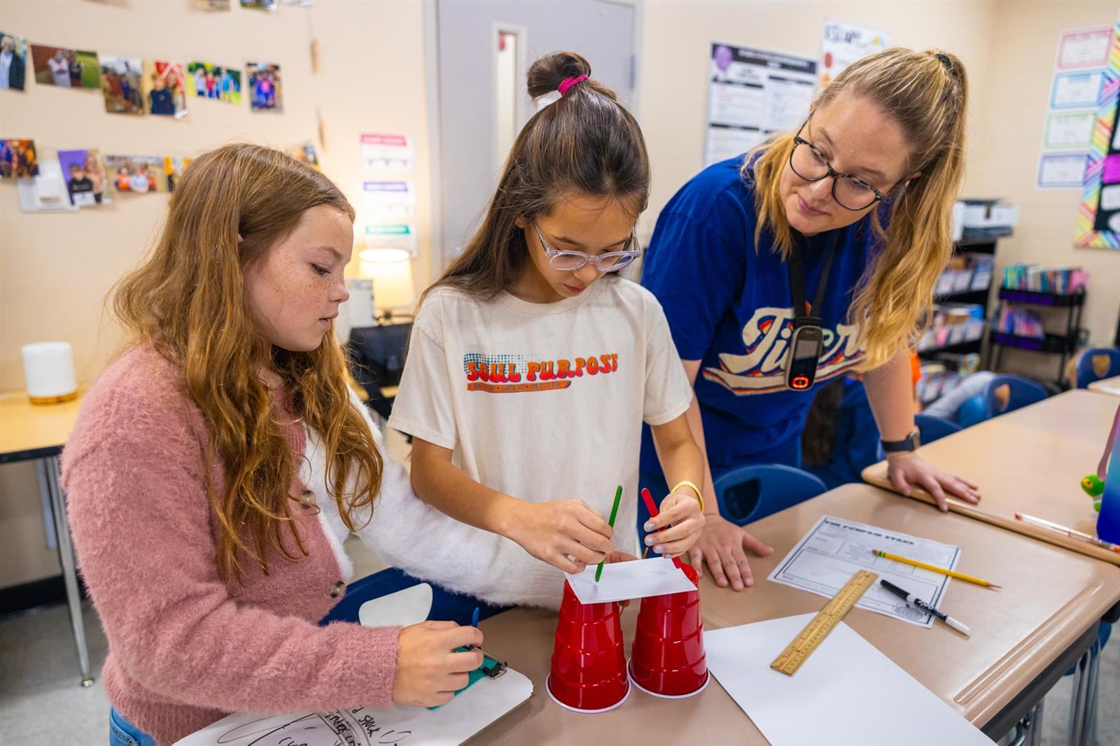 teacher and two girls working on a STEM project